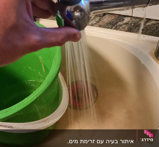 ברז מים זורם בכיור עם קערה ירוקה